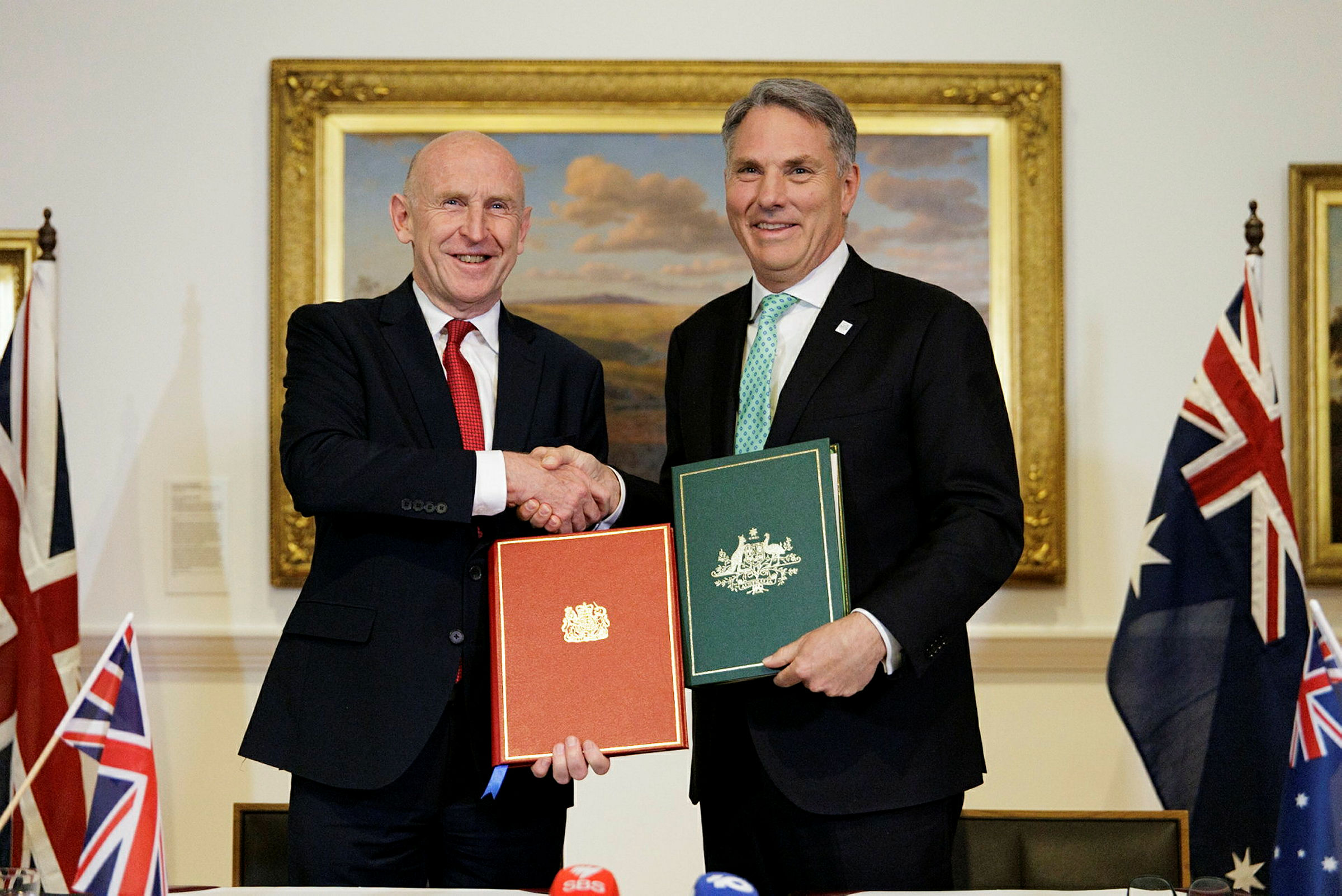 The Honourable Richard Marles MP, Deputy Prime Minister and Minister for Defence, Australia and the Right Honourable John Healey MP, Secretary of State for Defence, United Kingdom (UK) standing side by side shaking hands and presenting the signed bilateral Nuclear-Powered Submarine Partnership and Collaboration Treaty (the Geelong Treaty) at the UK- Australia Defence Ministers' Meeting in Geelong, Victoria