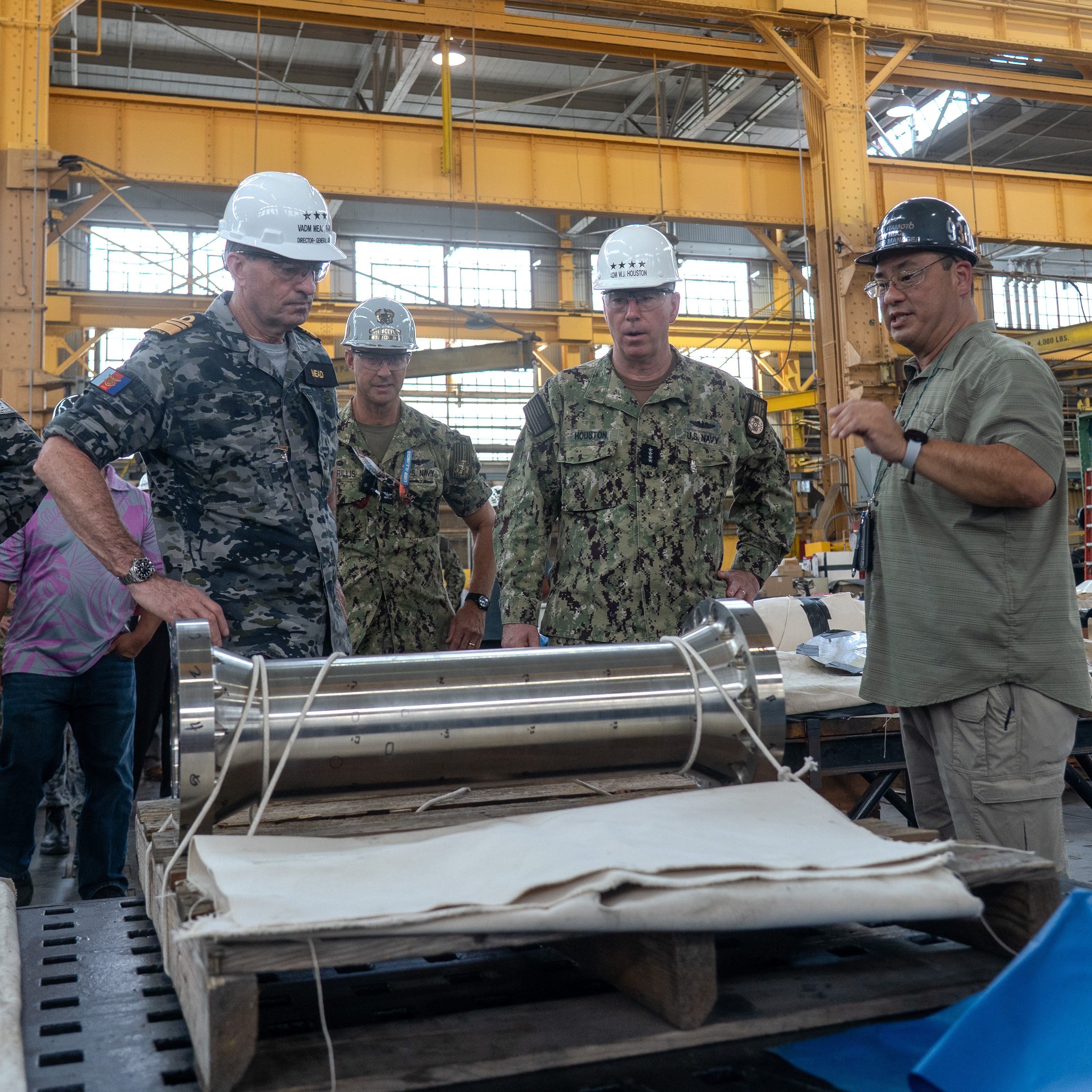 Royal Australian Navy VADM Jonathan Mead, Director-General of the Australian Submarine Agency (left), and U.S. Navy Adm. William Houston, Director, Naval Nuclear Propulsion Program (centre), receive a technical briefing during a walkthrough of Pearl Harbor Naval Shipyard & Intermediate Maintenance Facility’s machine shop.