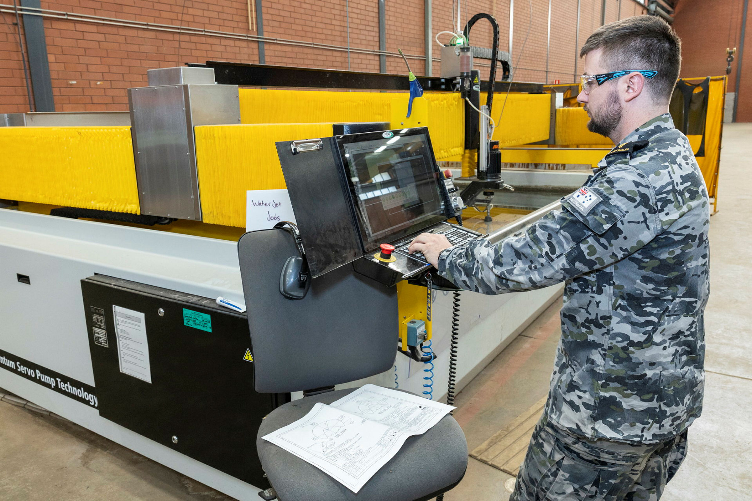 A Sailor operating a waterjet cutter at Fleet Support Unit - West, HMAS Stirling, WA
