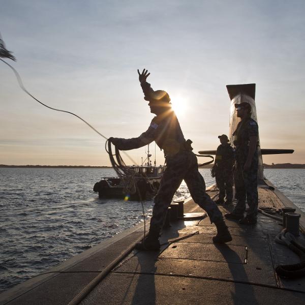 Able Seaman Acoustic Warfare Analyst Submariner Liam Shelley throws a heaving line to a tug boat as HMAS Waller prepares to come alongside Fleet Base West.