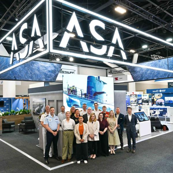 representatives for the ASA at the 2025 Indopac event stand together for a group photo with the ASA kiosk behind them.