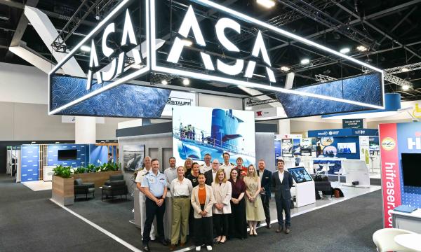 representatives for the ASA at the 2025 Indopac event stand together for a group photo with the ASA kiosk behind them.