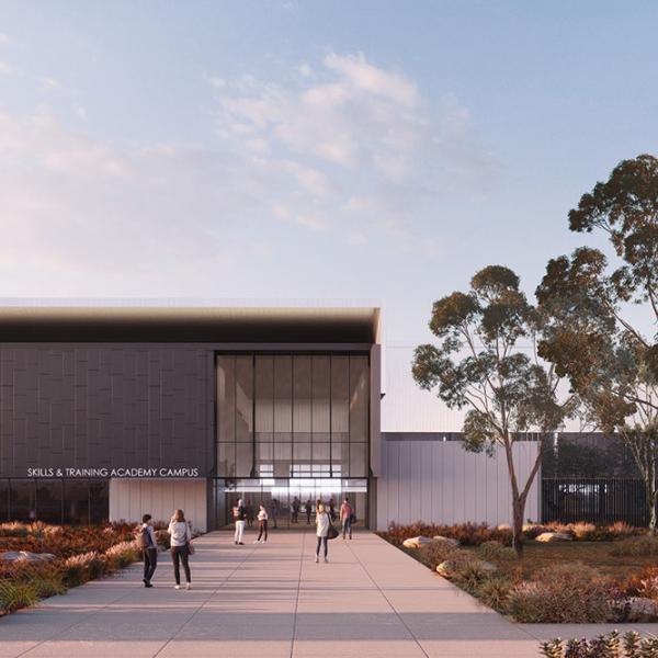 Modern training campus building with glass entry, trees and people walking along a landscaped path.